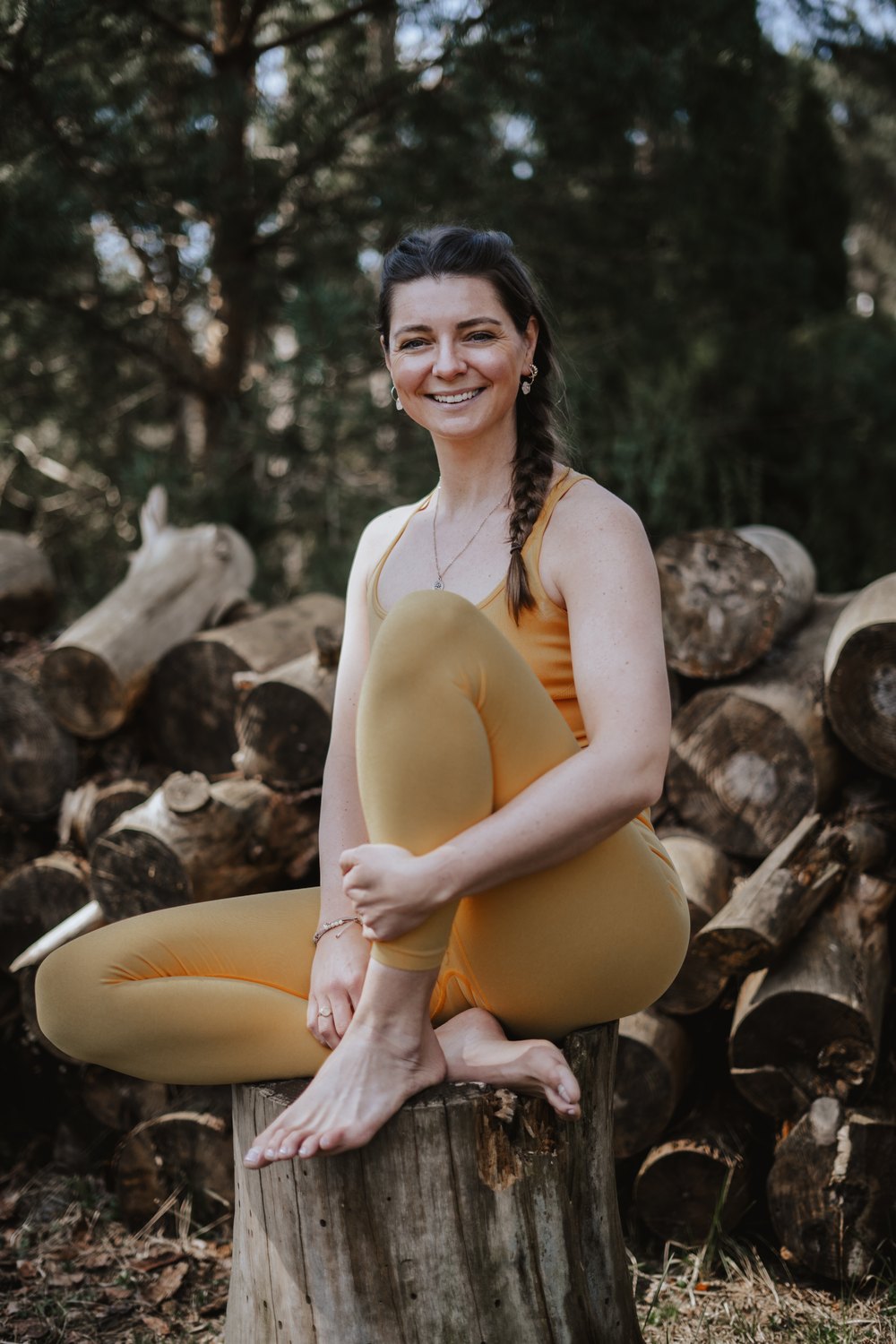 Fabienne von Gahlen sitzend auf Baumstumpf – Yogalehrerin in Dortmund