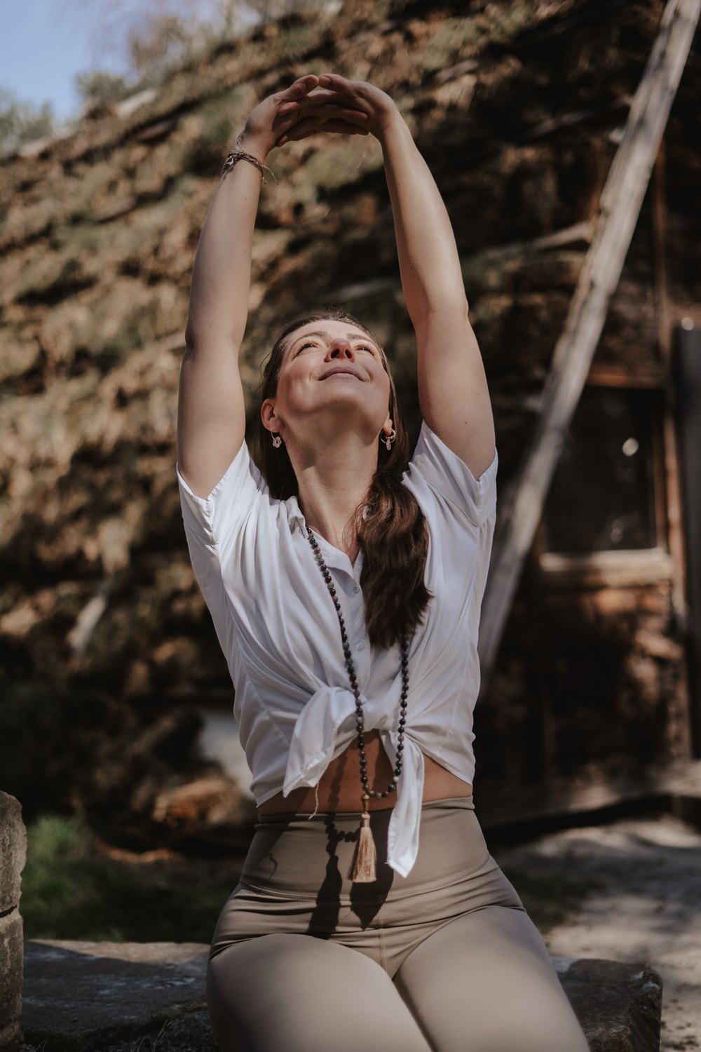 Fabienne in Yoga-Pose mit erhobenen Armen im Wald